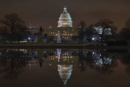 The Capitol is mirrored in the Reflecting Pool in Washington, as a partial government shutdown heads into a second week, Friday night, Dec. 28, 2018. Both chambers of Congress are gone, likely leaving the impasse till next week when the Democrats take control of the House of Representatives. (AP Photo/J. Scott Applewhite)
