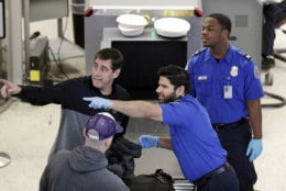 A Transportation Security Administration (TSA) officer directs a traveler as another looks on at a security screening area during a partial federal government shutdown Monday, Dec. 31, 2018, in SeaTac, Wash. TSA staff are among tens of thousands of federal employees considered essential as the federal government shutdown moves into its second week. They are working without pay until the shutdown ends, but will likely be paid retroactively later on. (AP Photo/Elaine Thompson)