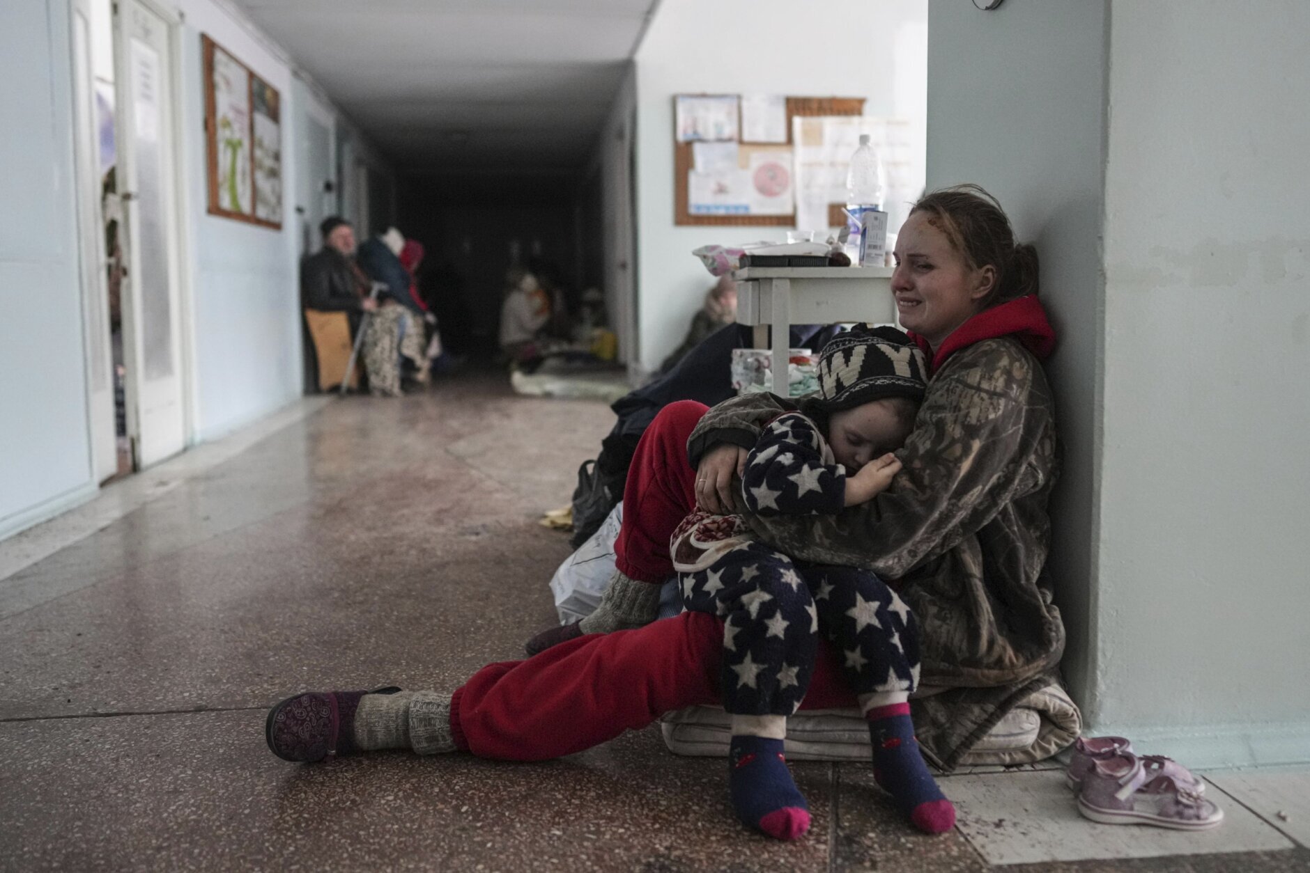 Anastasia Erashova cries as she hugs her child in a corridor of a hospital in Mariupol, eastern Ukraine on Friday, March 11, 2022. Anastasia's other child was killed during the shelling of Mariupol. (AP Photo/Evgeniy Maloletka)