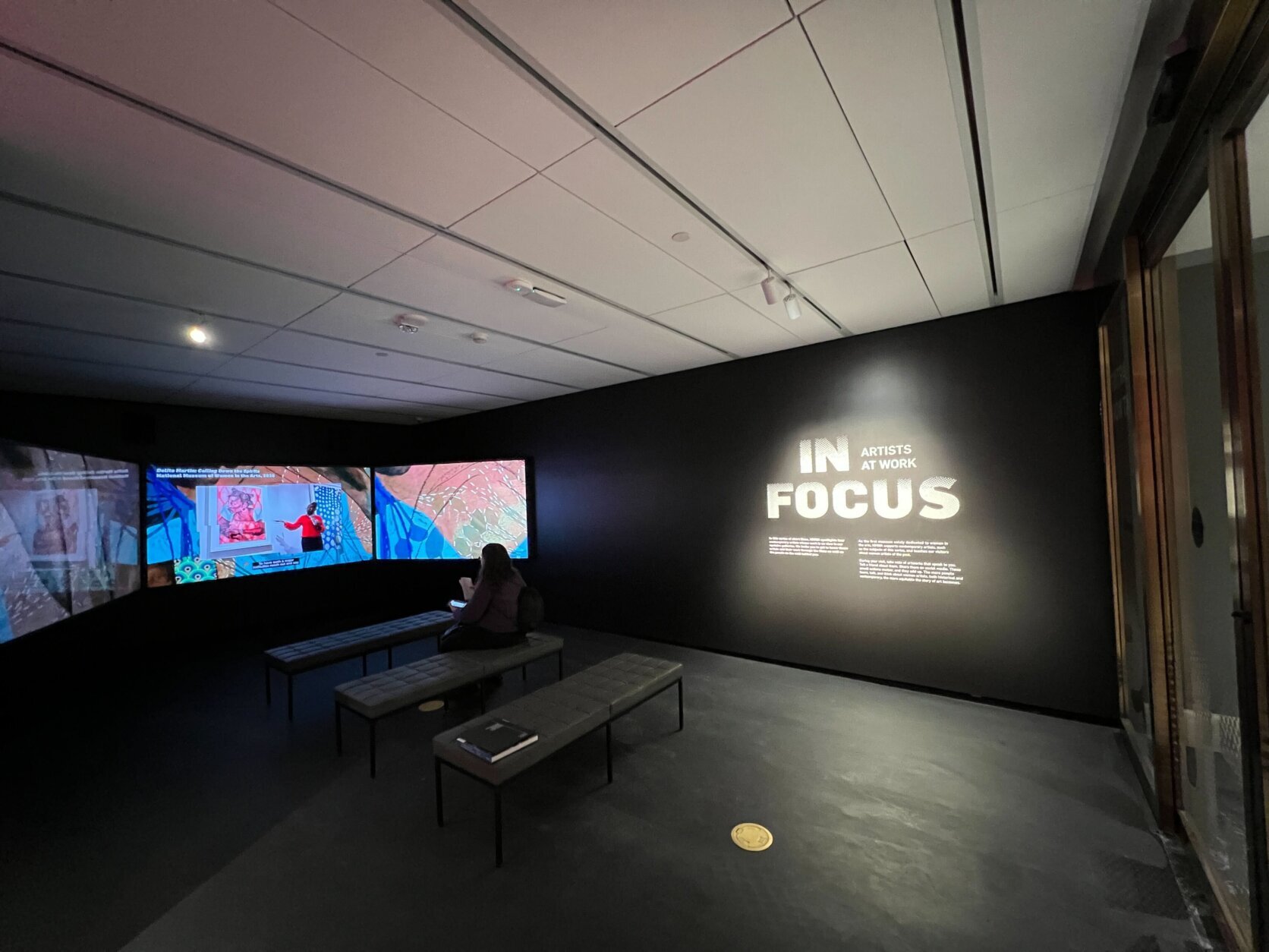 Multiple screens in a room with rows of seats