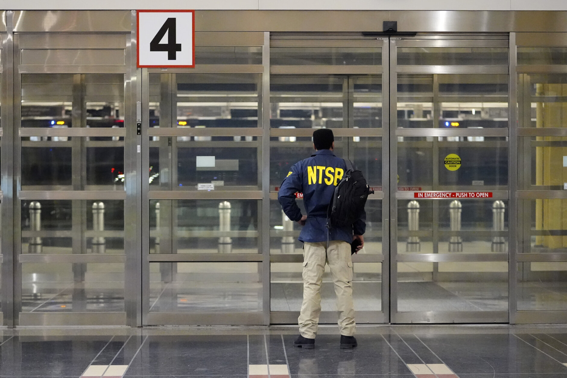 A member of the National Transportation Safety Board (NTSB) stands by a door at Ronald Reagan Washington National Airport, Wednesday, Jan. 29, 2025, in Arlington, Va. (AP Photo/Julio Cortez)