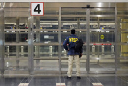 A member of the National Transportation Safety Board (NTSB) stands by a door at Ronald Reagan Washington National Airport, Wednesday, Jan. 29, 2025, in Arlington, Va. (AP Photo/Julio Cortez)